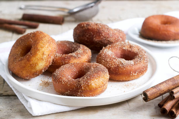 istock Homemade donuts with sugar and cinnamon on a wooden background. Rustic style. 1094204524