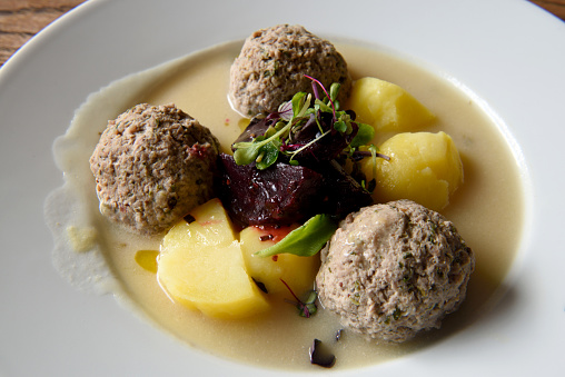 Prussian specialty of Konigsberger Klopse boiled meatballs in a white sauce with anchovy, young potatoes, capers and beet root.