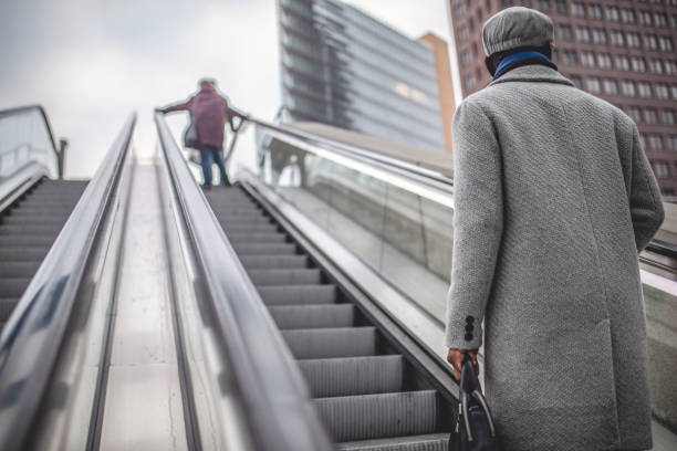 istock Businessman in winter coat riding a escalator 1094219642