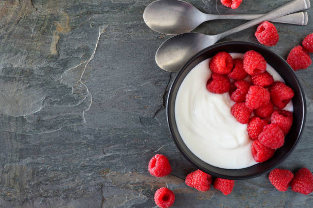 istock Yogurt with raspberries, top view, side border on a slate background 1094246798