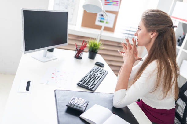 istock A young girl sitting at a computer Desk and working with documents. 1094250364