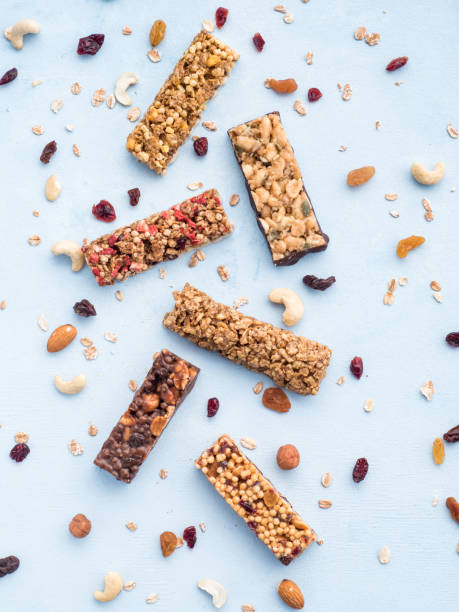 conjunto de barritas diversas sobre fondo azul - protein bar cereal oat cranberry fotografías e imágenes de stock