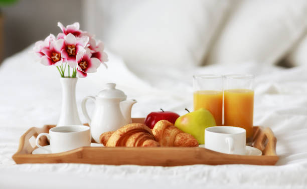 завтрак в постели кофе, круассаны, апельсиновый сок и фрукты на подносе - pillow bedroom bed rural scene стоковые фото и изображения
