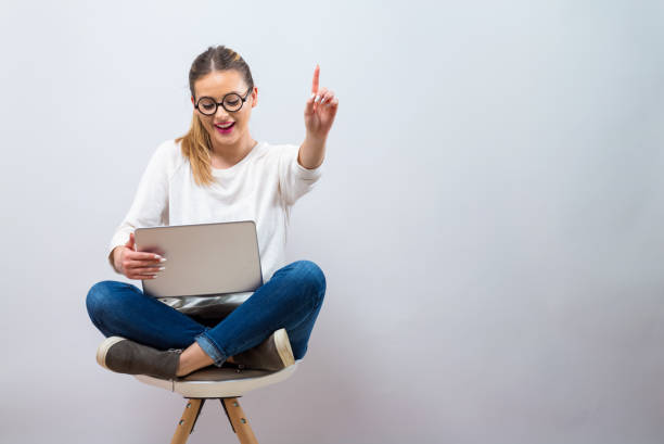 istock Young woman with a laptop computer pointing something 1094263482
