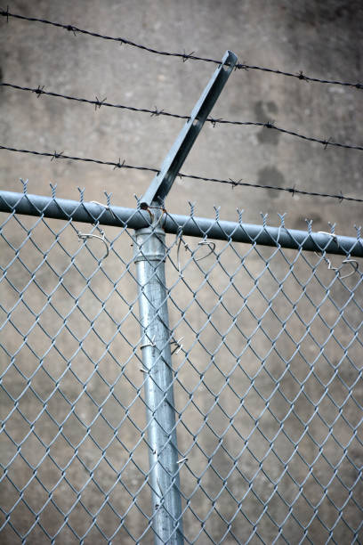 istock Barbed wire fence around a concrete building 1094275410