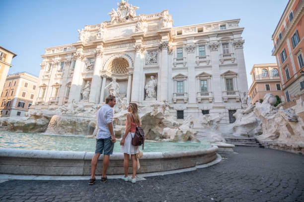 Couple contemplating the Trevi fountain in Rome, Italy stock photo