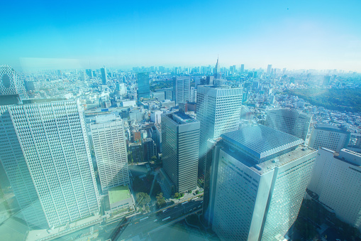 Tokyo, Japan, viewed from a high angle, seeing the skyline of the city in the business district. Looking through the glass on the view point