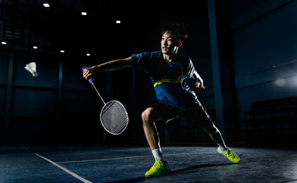 Asian badminton player is hitting in court Asian badminton player is hitting in court playing badminton stock pictures, royalty-free photos & images