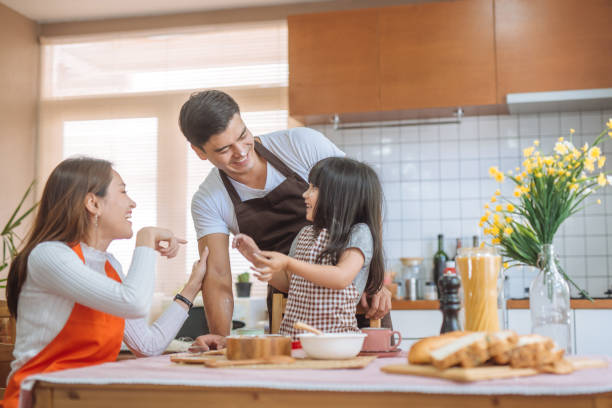 familie tochter und eltern, die vorbereitung der backen - two parent family indoors home interior domestic kitchen stock-fotos und bilder