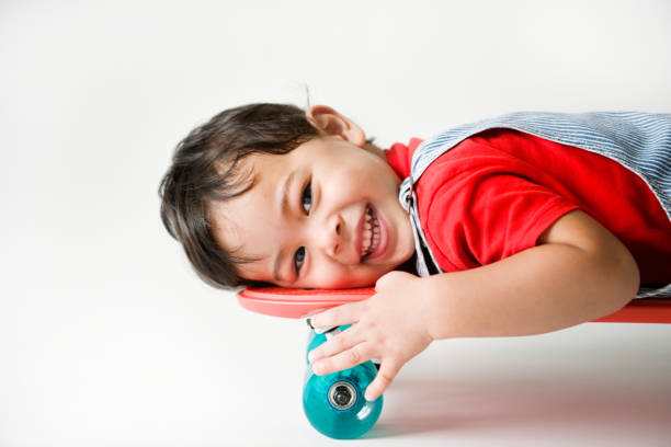 Closeup of a cheerful boy lying on a skateboard