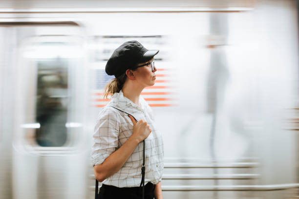 Thoughtful woman waiting for a train at a subway platform Thoughtful woman waiting for a train at a subway platform standing on subway platform stock pictures, royalty-free photos & images