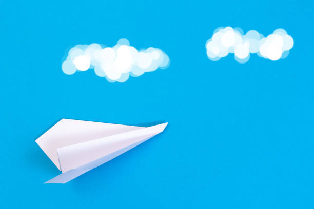 istock Paper origami plane in blue sky with white clouds 1094312098
