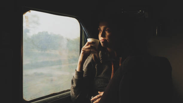 istock Young women drinking water while looking out of a asian train window 1094314788