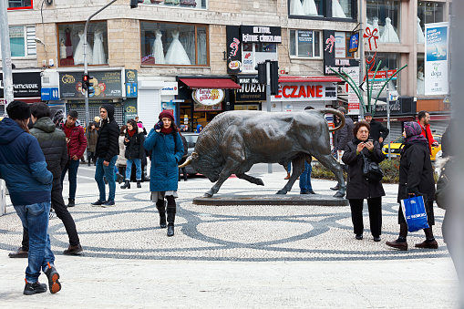 Istanbul, Turkey - January 13, 2019: People are walking next to the bull statue at the Kadikoy square. Often it is used as a meeting point in the Kadikoy, Istanbul.