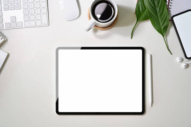 istock Office white desk with blank screen tablet, mobile phone, coffee mug and copy space 1094324526