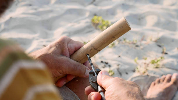 istock Senior man sits on the beach and making flute by hands, close-up. 1094325252