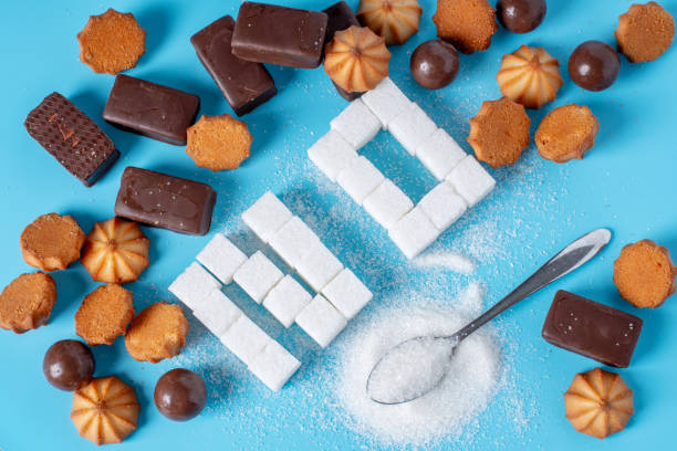 Text No is lined with sugar cubes and sweets. Harm to the health of sweet and rejection of sucrose stock photo
