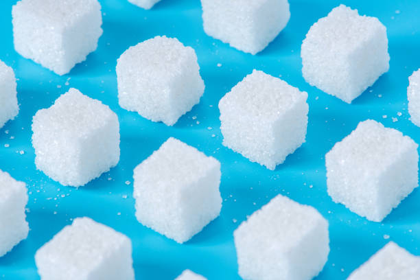 istock Pattern of sugar refined cubes with shadows on a blue background. Concept of harmful ingredient for confectionery 1094331434