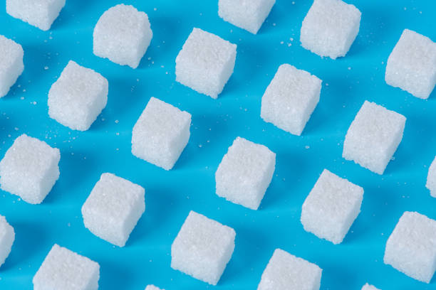 istock Pattern of sugar refined cubes with shadows on a blue background. Concept of harmful ingredient for confectionery 1094331440