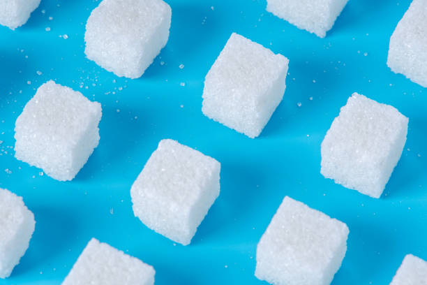 istock Pattern of sugar refined cubes with shadows on a blue background. Concept of harmful ingredient for confectionery 1094331442