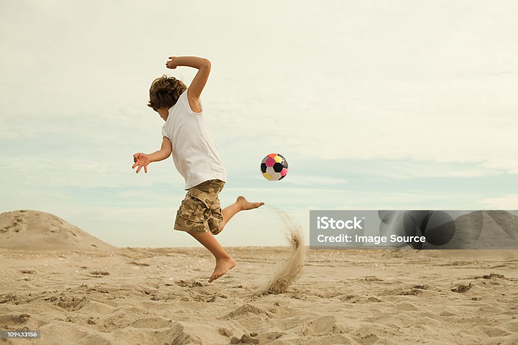 Garçons coup de pied de football sur la plage - Photo de Plage libre de droits