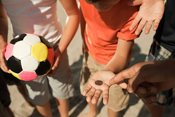 garotos jogando uma moeda - football human hand holding american football - fotografias e filmes do acervo