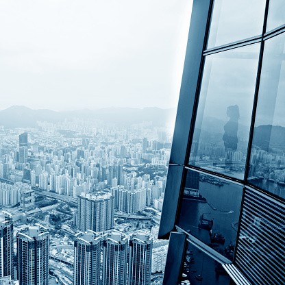 Businesswoman standing in a skyscraper building viewing over the city.