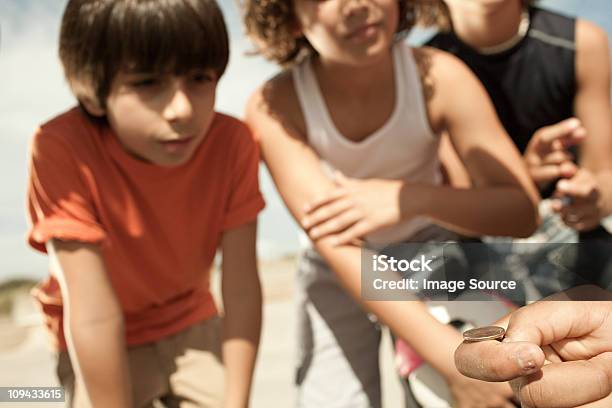 Rapazes Atirando Uma Moeda - Fotografias de stock e mais imagens de Lançar a moeda ao ar - Lançar a moeda ao ar, Adolescente, 10-11 Anos