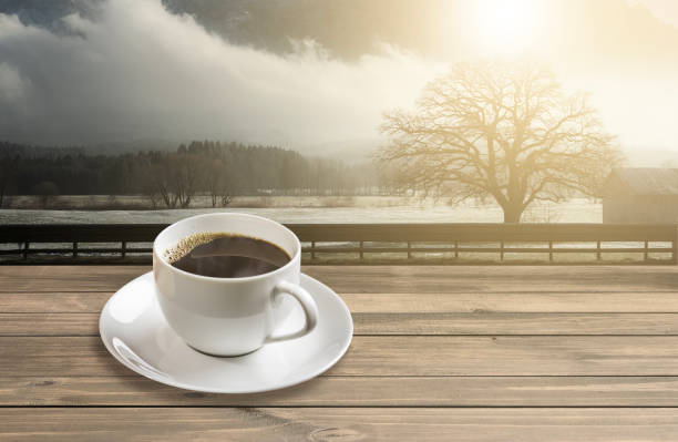 istock Hot americano black coffee in white mug with sunrise mountain background 1094338070