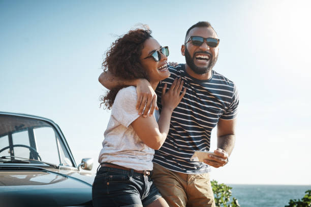 Nothing inspires happiness like love Shot of a young couple enjoying a summer’s road trip together taking a break photos stock pictures, royalty-free photos & images