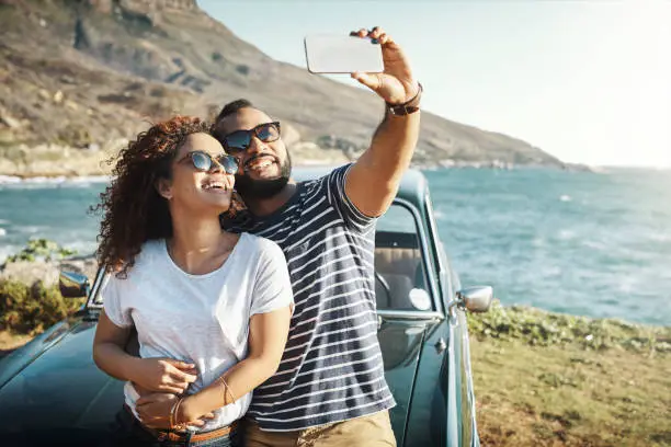 Shot of a young couple taking a selfie on a road trip