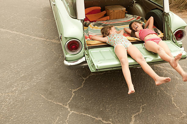 two girls lying in estate car - motor vehicle road trip western usa southern california 뉴스 사진 이미지