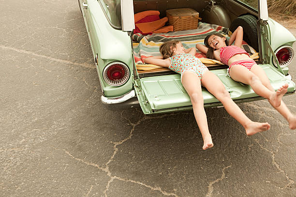Two girls lying in estate car  swimwear photos stock pictures, royalty-free photos & images