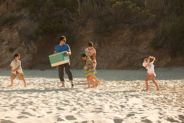 famille sur la plage, père porter coolbox - bubble wand outdoors little boys mother photos et images de collection