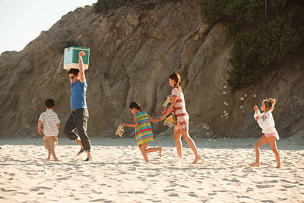 famille sur la plage, père porter coolbox - bubble wand outdoors little boys mother photos et images de collection