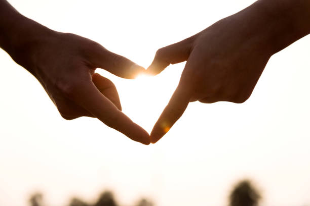 istock Hands forming a heart shape at sunset 1094346006