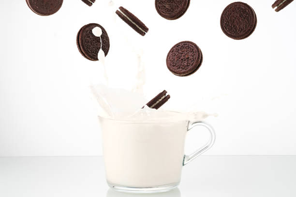 Cookies splash. Chocolate biscuit falling in milk. Pouring Milk Splash cookies