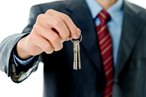 Businessman in suit handing key