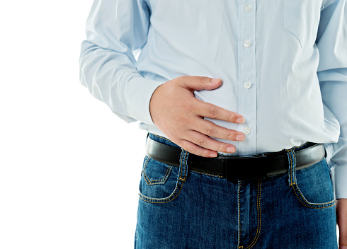 Closeup of overweight man holding his stomach
