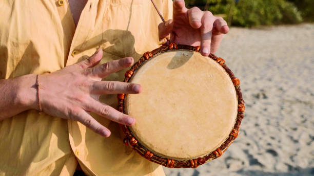 istock Man playing on a drum with his hands, close up. Hands tapping a small drum 1094351464