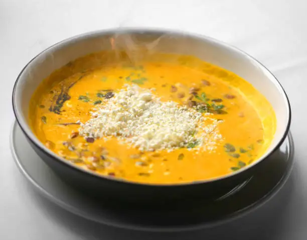 Macro photo of pumpkin soup with sour cream in a restaurant