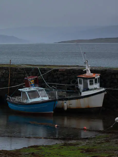 Photo of scottish fishing boats at dusk on the isle of skye