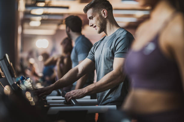 istock Happy athletic man adjusting speed on treadmill in a gym. 1094355126
