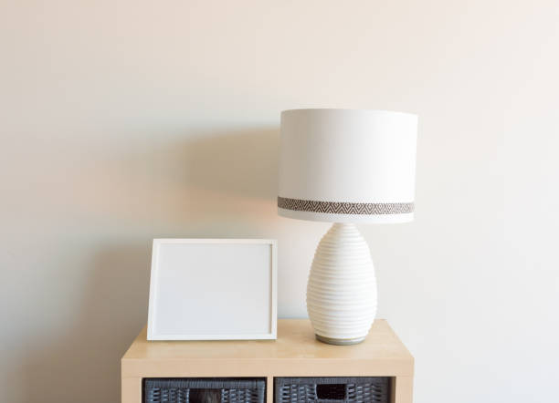 istock Blank picture frame and lamp on wooden shelf 1094357234