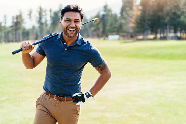 Cheerful golf player Indian ethnicity golf player walking on the course playing alone stock pictures, royalty-free photos & images