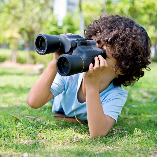 istock Little boy holding a binocular at park 1094358380