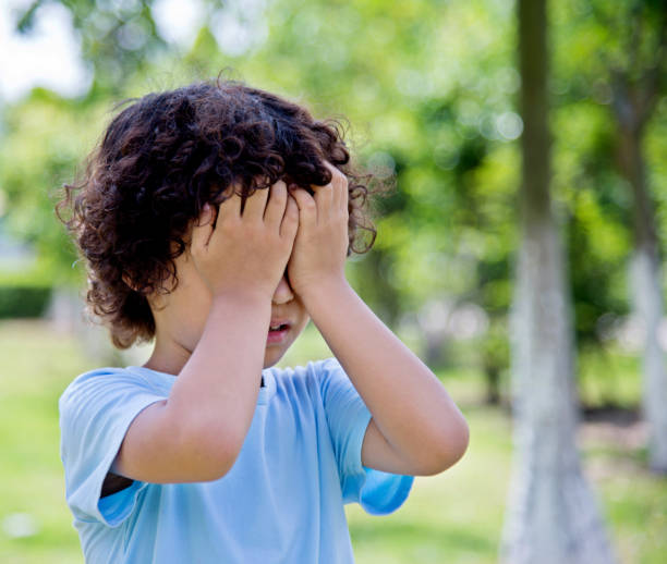 istock Little asian boy covering eyes in a park 1094358514