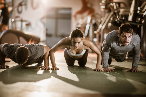 istock Group of young athletes exercising push-ups in a gym. 1094358526