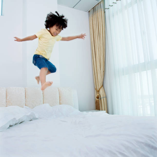 istock Little boy jumping on the bed 1094358560