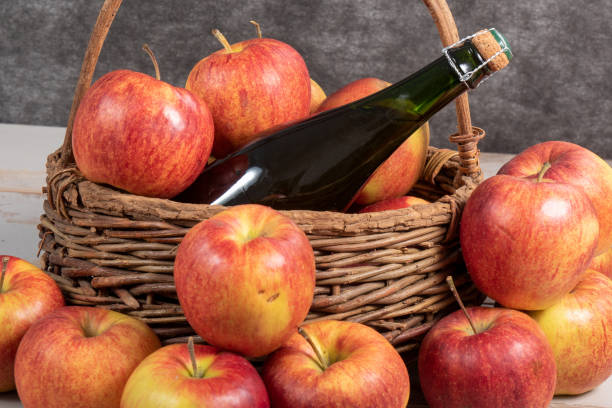 bottle of cider and beautiful organic apples a bottle of cider and beautiful organic apples vinegar stock pictures, royalty-free photos & images